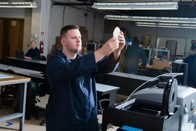 student holding up product in workshop