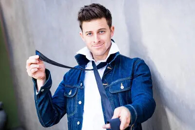 K-Von comedian in denim jacket holding tie