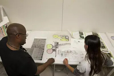 back view of male teacher working in studio with female student
