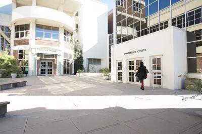 person walking outside front entrance of college