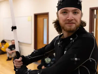 student in green screen suit