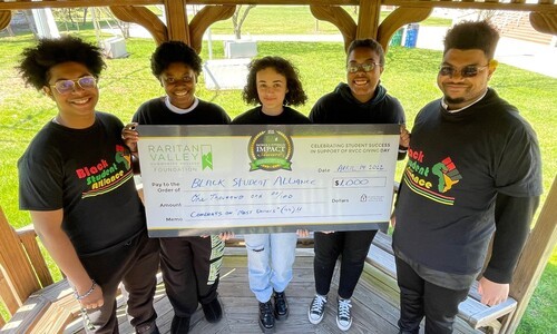 5 students holding large check
