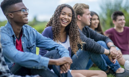 group of teens sitting outside
