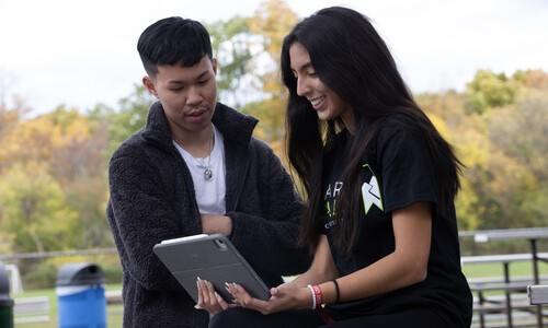 female student with long nails holding laptop with male student