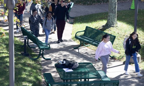 students walking near benches and picnic tables