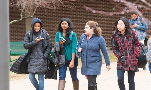 four female students walking outside together