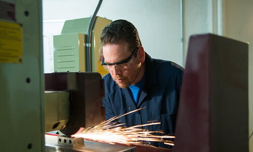 man working on machine with sparks