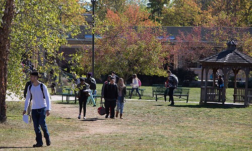 students walking outside with autumn trees