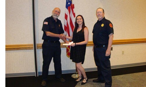 girl getting scholarship from fire police members