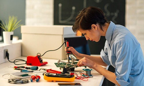 woman soldering circuit board