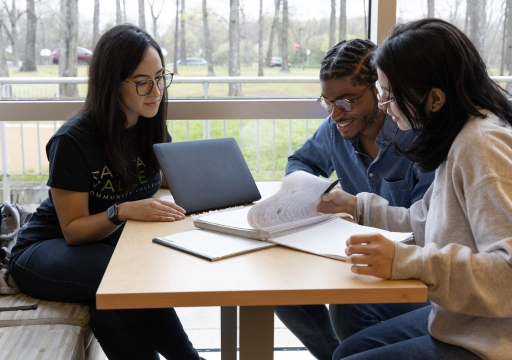 Image of three students working at a table in the student center.