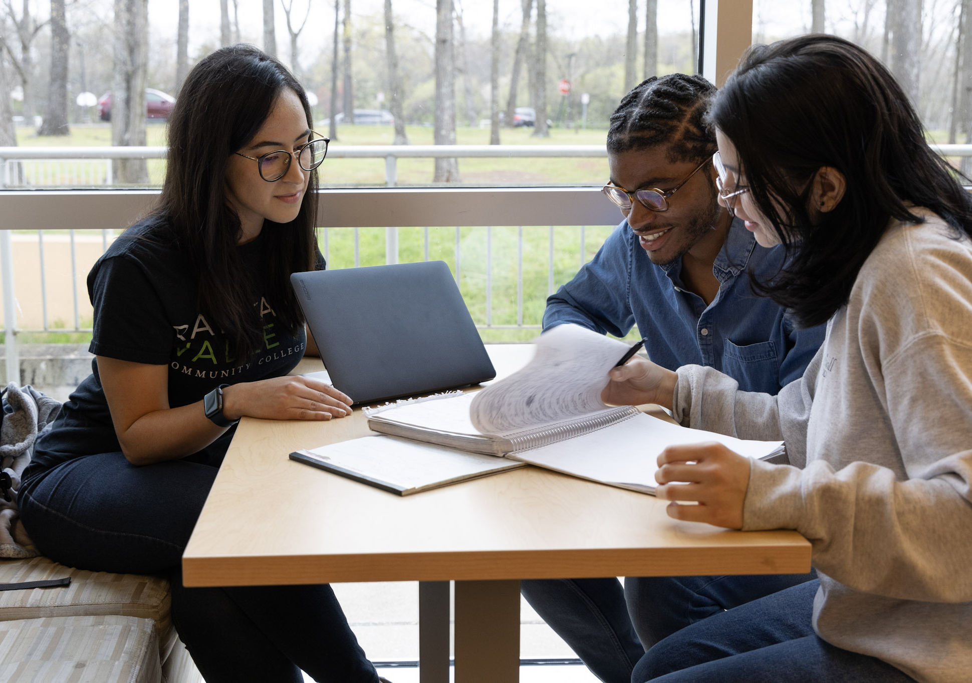 Image of three students working at a table in the student center.