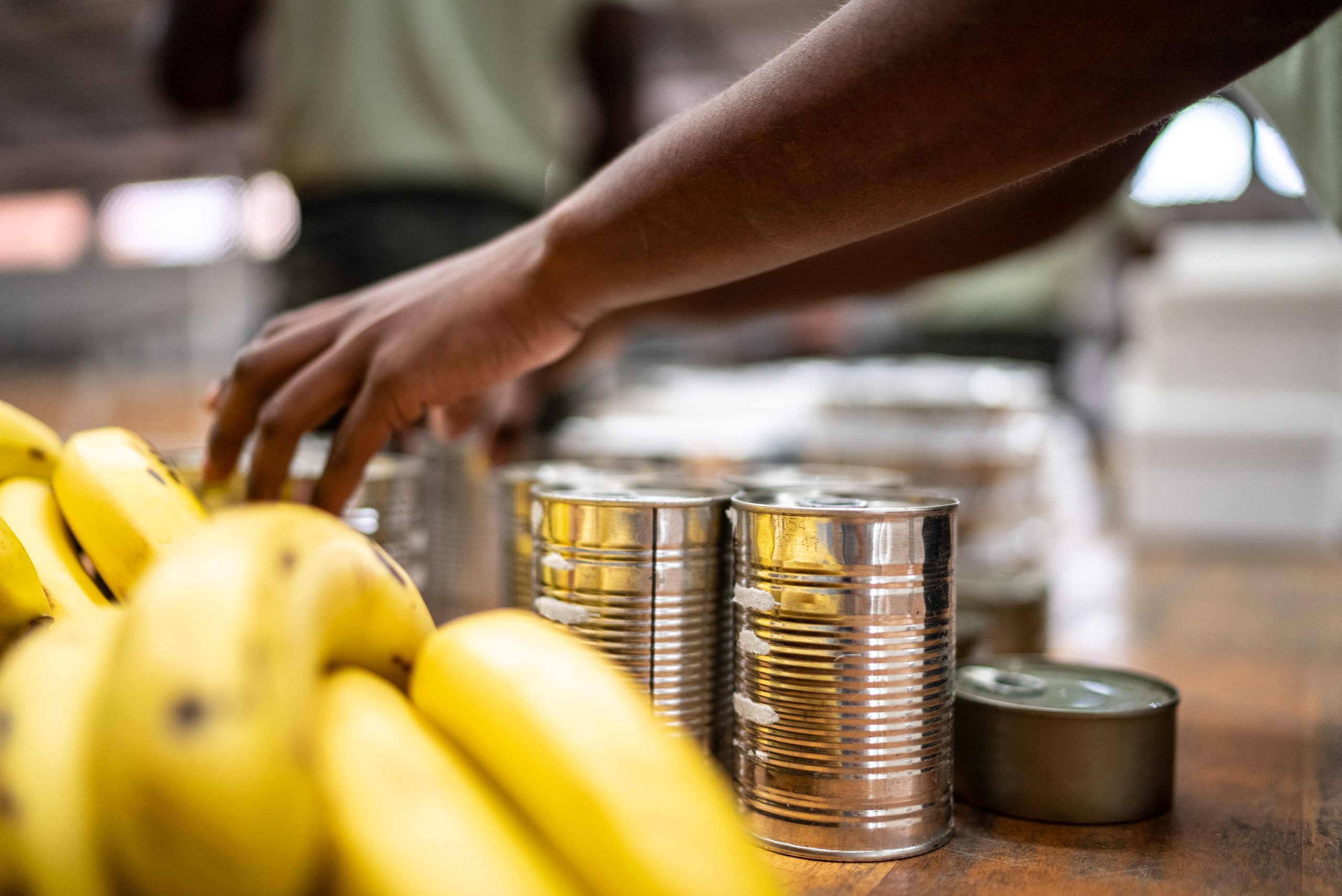 Hands placing canned food on the table at a community center