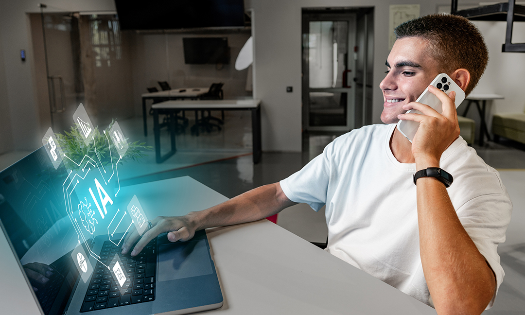 In a contemporary office, a young man smiles while on a phone call, interacting with artificial intelligence features displayed on his laptop. The setting is bright and minimalist.