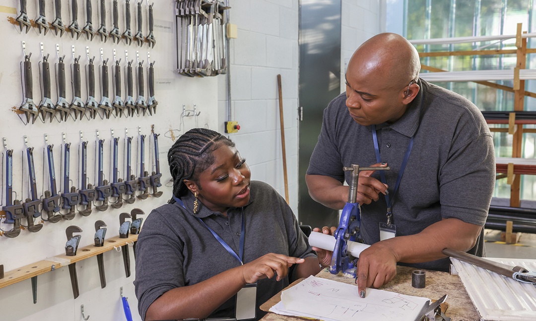 Deaf man and woman in wheelchair working in workshop