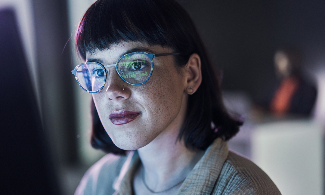 Business woman face, computer of young employee with blue light and glasses. Digital code, hacker ai and reading of a female worker at night planning with online google analytics