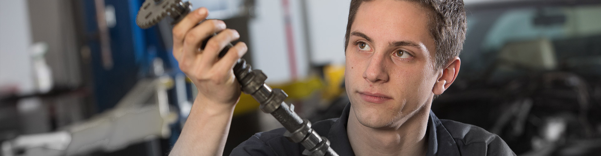 automotive technician holding car part