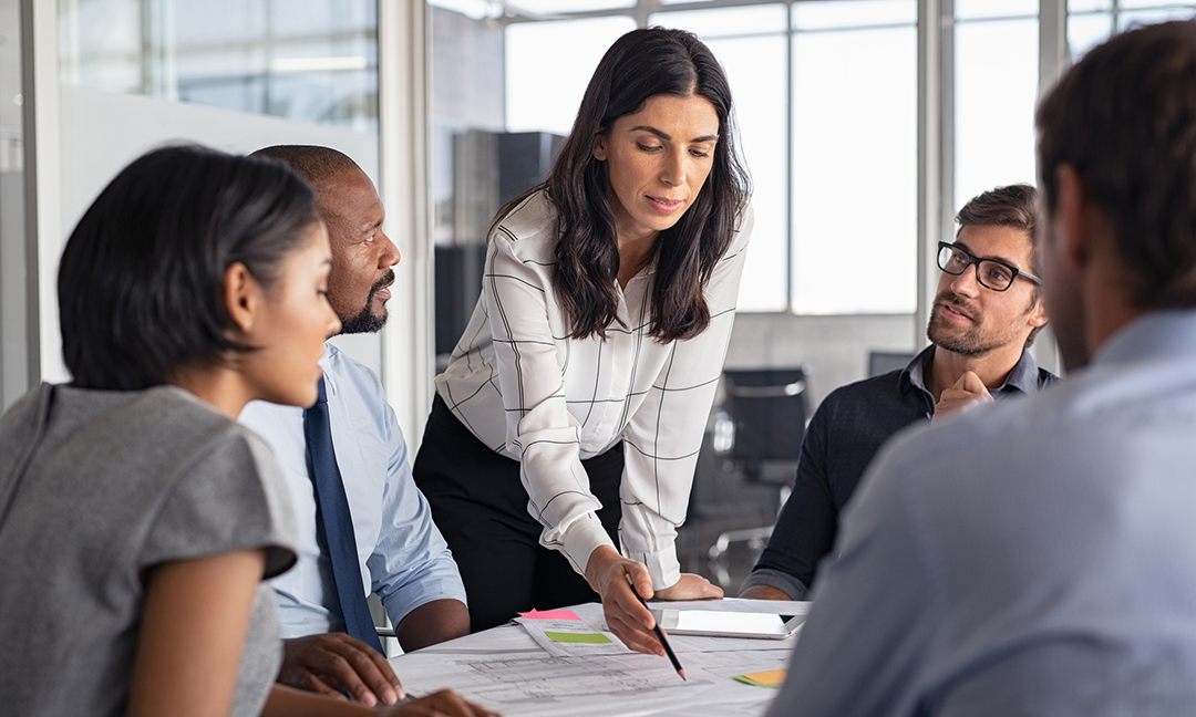 Business woman with business team in conference room working on project.
