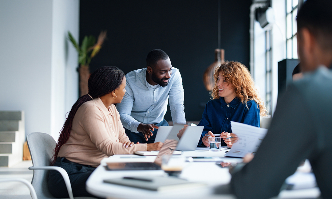 A group of colleagues working together in a contemporary office environment, focused on collaboration and teamwork to achieve professional goals. This setting embodies a productive and dynamic workplace atmosphere.