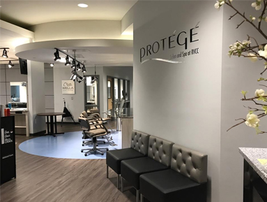 Alt text: The Protégé Salon at RVCC features a modern, professional salon environment with styling stations, salon chairs, comfortable seating, and contemporary décor, providing students with hands-on training in a real-world salon setting.