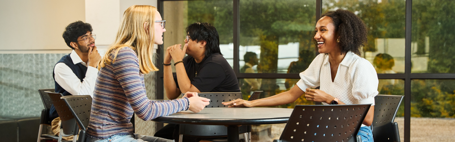 Image of students talking while sitting in the cafeteria.