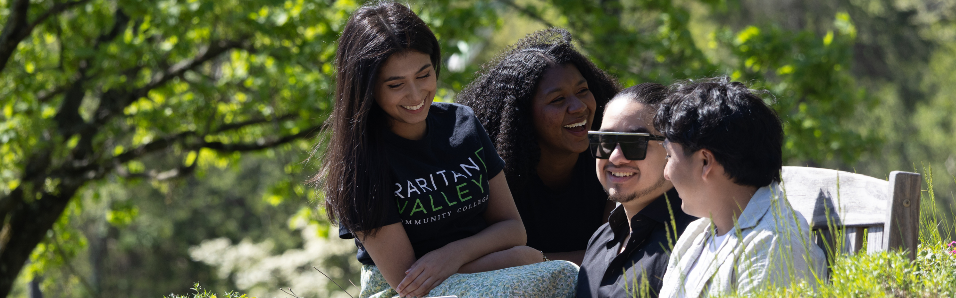 An image of four RVCC students talking at a bench outside on campus.