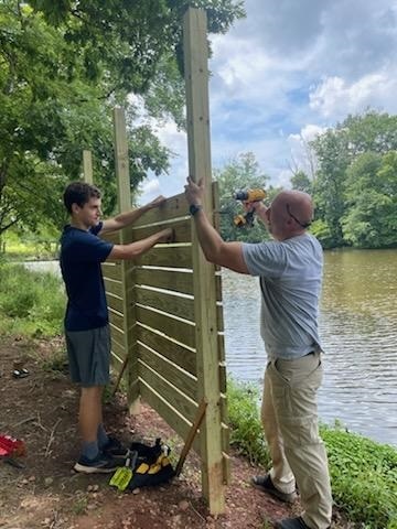 two rvcc ces interns building a fence