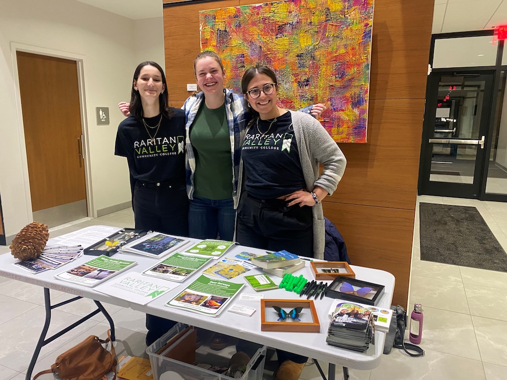 three rvcc ces interns at behind a table of flyers and handouts