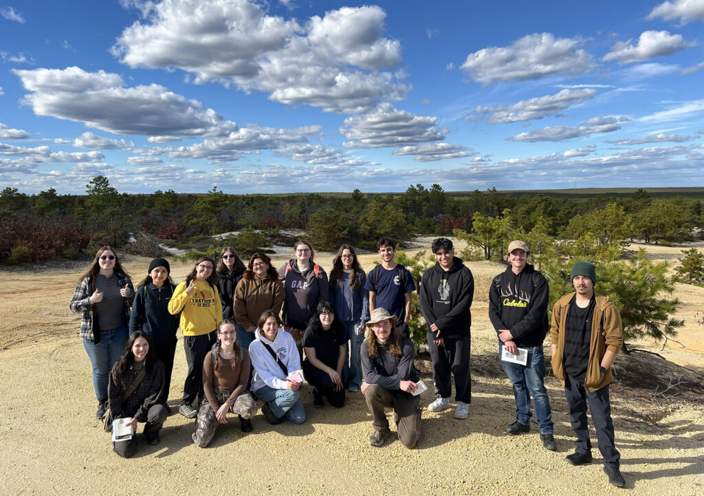 group of students on beach with blue sky and coulds