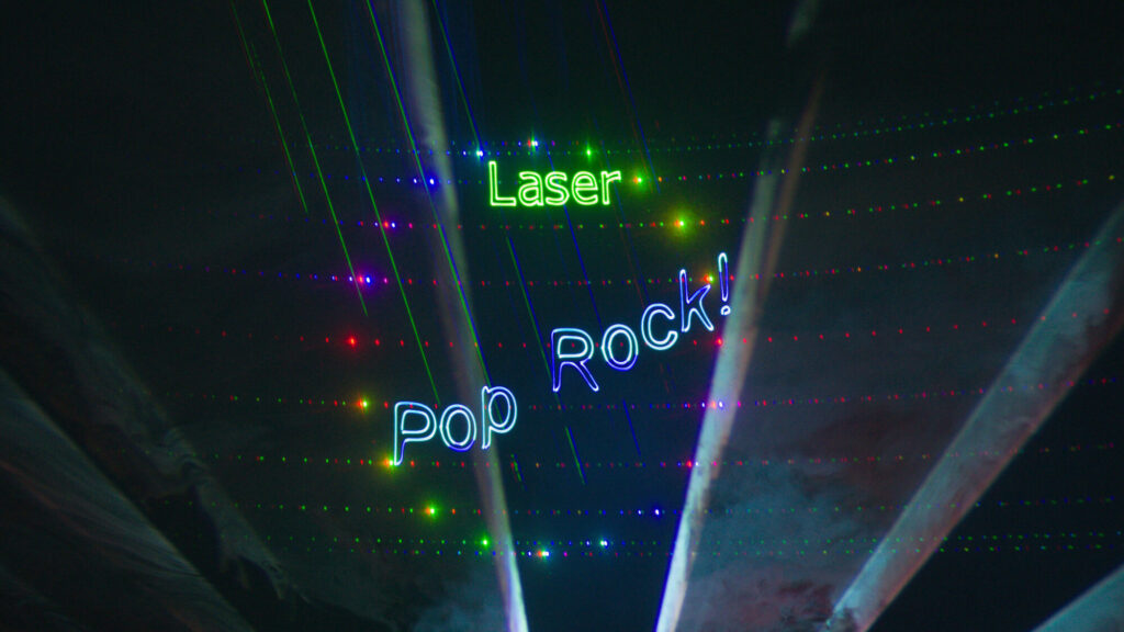 Colorful laser beams and spotlights fill a dark space with the words “Laser Pop Rock!” glowing in bright neon colors.